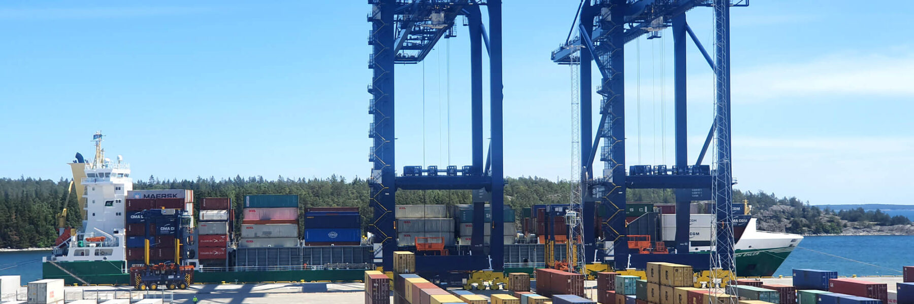 View of container yard at Hutchison Ports Stockholm with vessel docked in distance